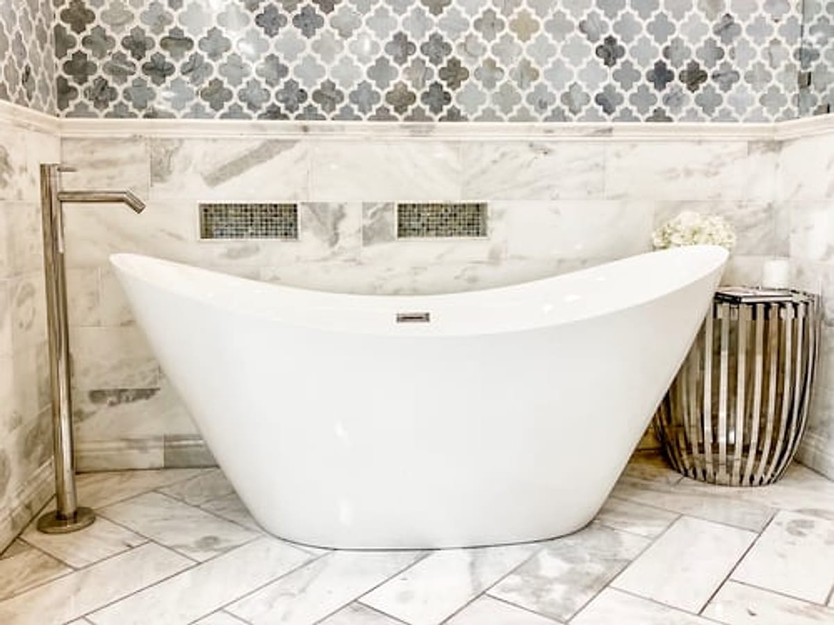 Remodeled Oklahoma City bathroom with a freestanding soaking tub and marble mosaic tile wall