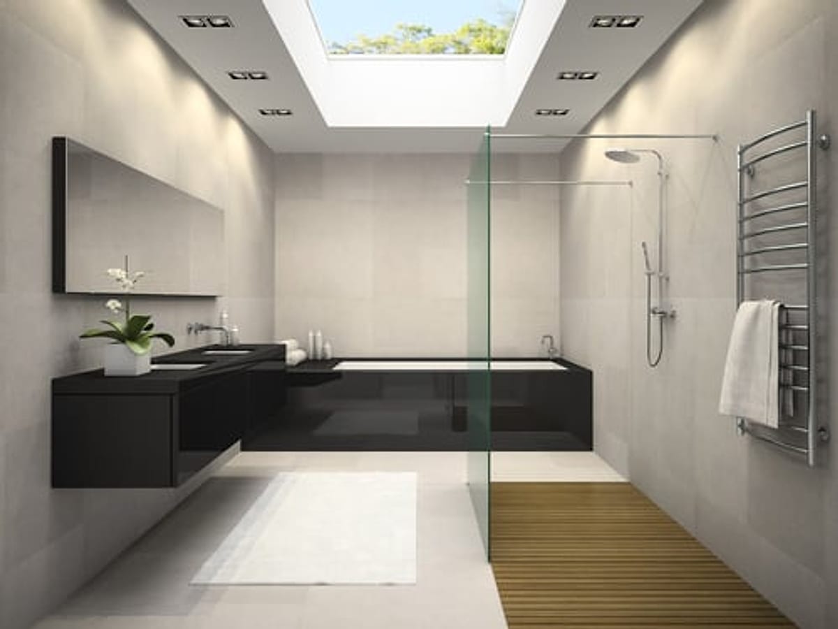 Modern walk-in shower with a frameless glass panel, large-format wall tile and a teak shower floor insert